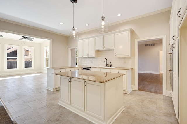 kitchen featuring kitchen peninsula, hanging light fixtures, sink, white cabinetry, and a center island