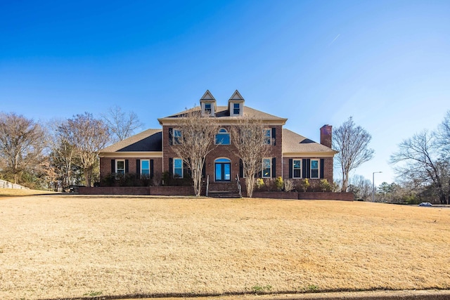 colonial inspired home with a front lawn