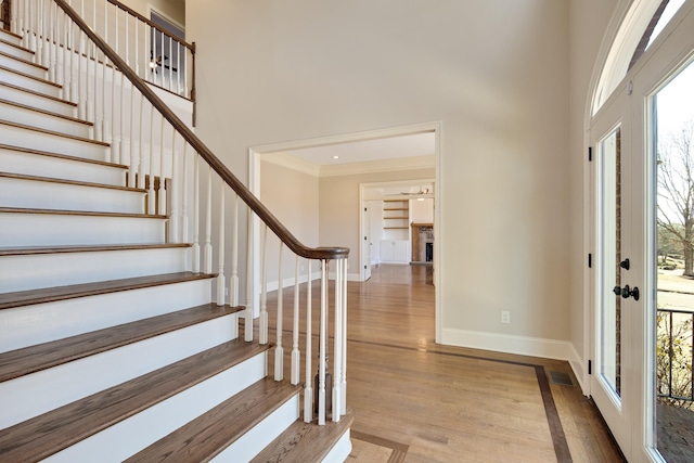 entrance foyer featuring crown molding and light hardwood / wood-style floors