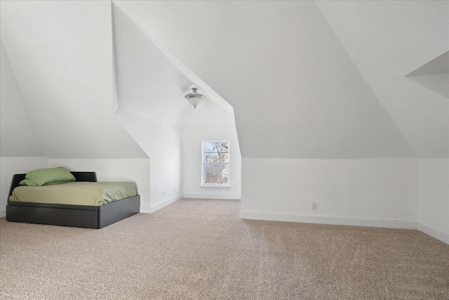 unfurnished bedroom with carpet flooring and lofted ceiling