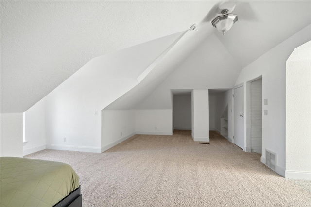 carpeted bedroom with vaulted ceiling