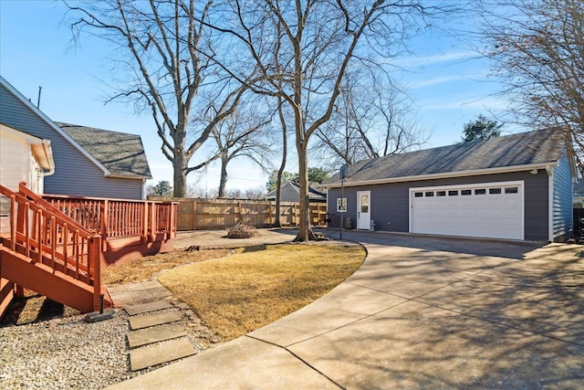 view of yard featuring a garage, an outbuilding, and a deck