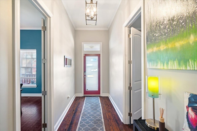 entryway with dark hardwood / wood-style floors, ornamental molding, and an inviting chandelier