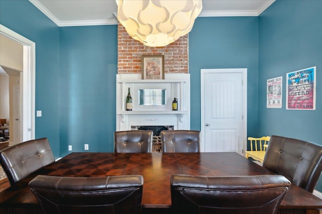 dining space with crown molding and a fireplace