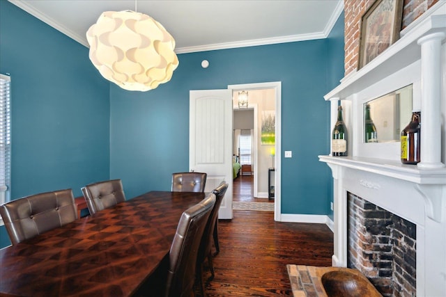 dining area with ornamental molding, a brick fireplace, and dark hardwood / wood-style flooring