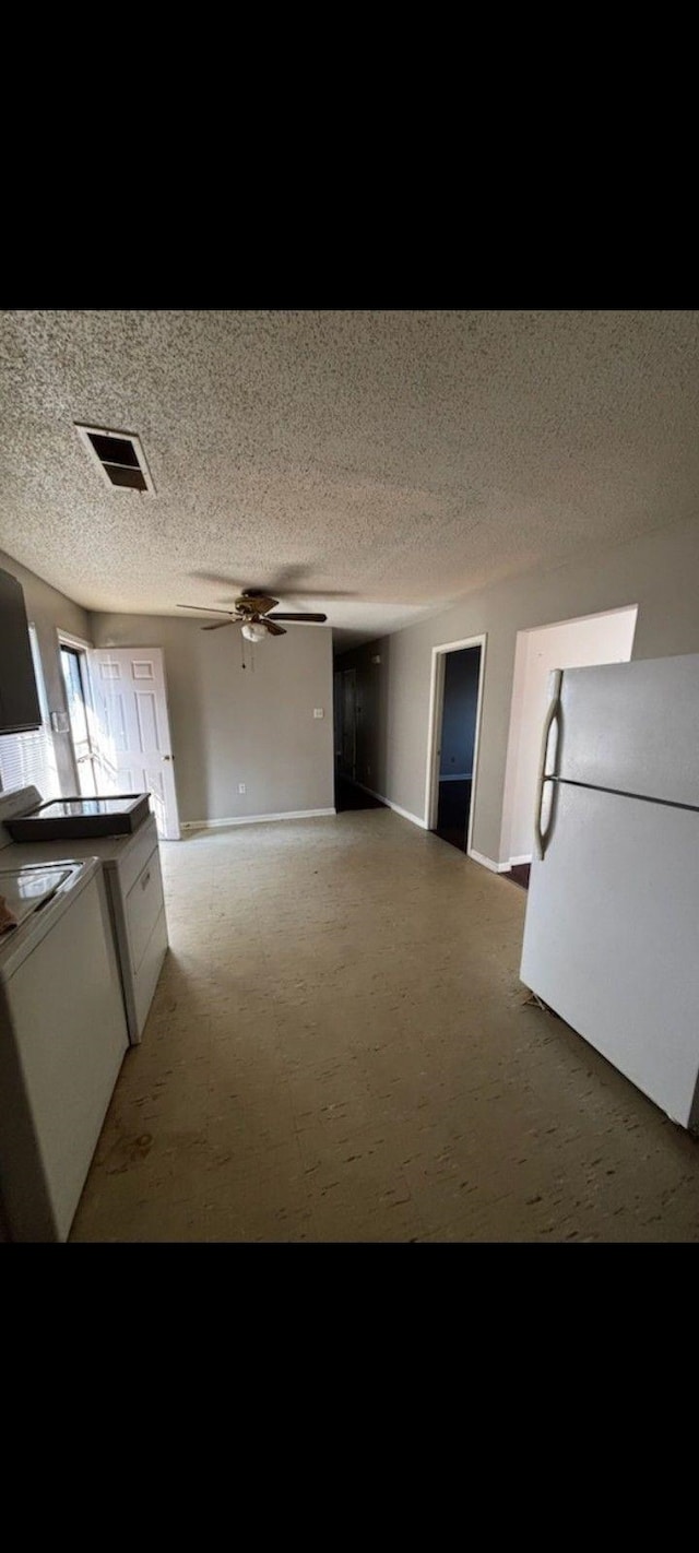 kitchen with white cabinetry, ceiling fan, and white fridge