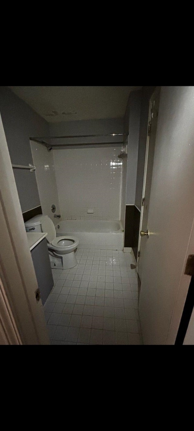 full bathroom with tub / shower combination, toilet, vanity, and tile patterned flooring