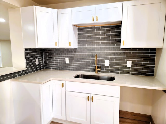 kitchen with sink, white cabinets, and decorative backsplash