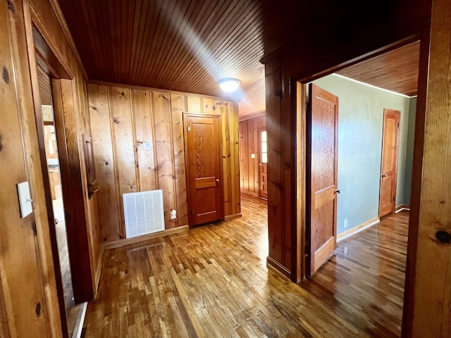 corridor featuring wood walls and light wood-type flooring