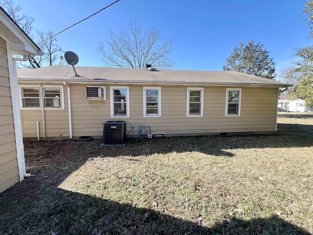 back of house featuring an AC wall unit, central AC unit, and a yard