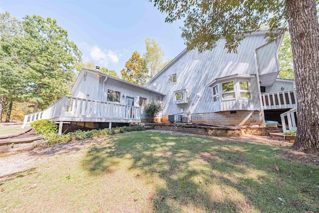 back of property featuring a wooden deck and a yard