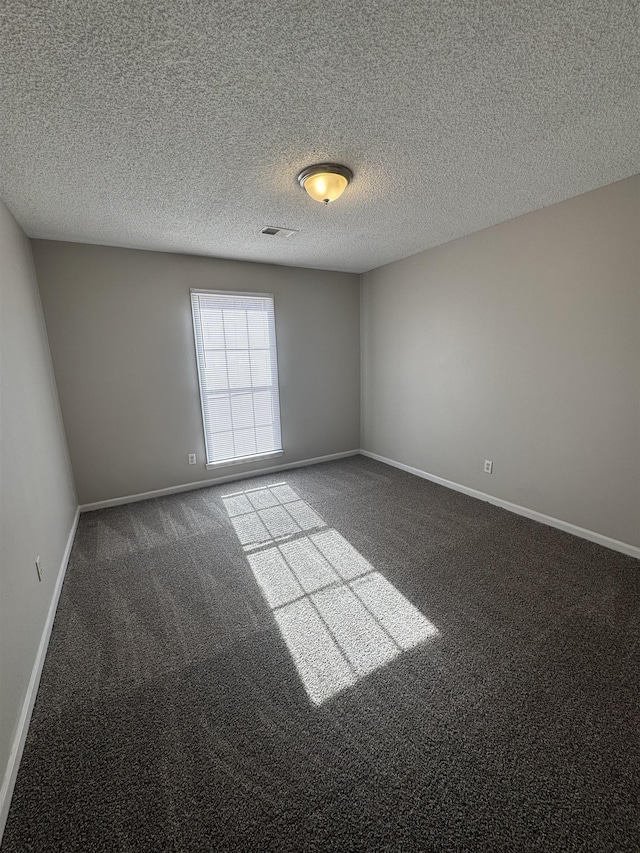 carpeted spare room with a textured ceiling