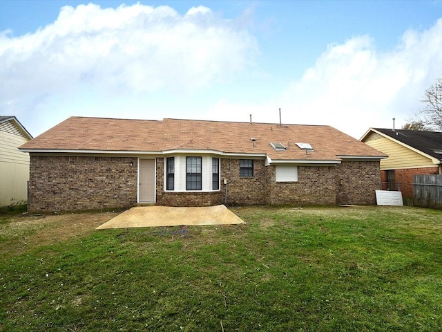 rear view of house with a patio and a lawn