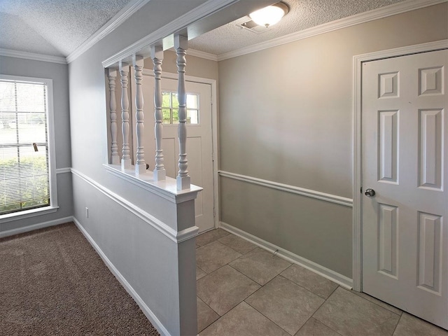 entryway featuring a textured ceiling, light tile patterned floors, crown molding, and vaulted ceiling