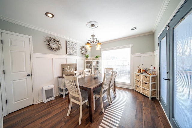 dining area with crown molding, a chandelier, heating unit, and dark hardwood / wood-style flooring