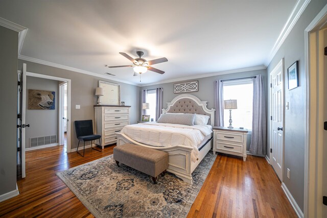 bedroom with ceiling fan, ornamental molding, and dark hardwood / wood-style floors