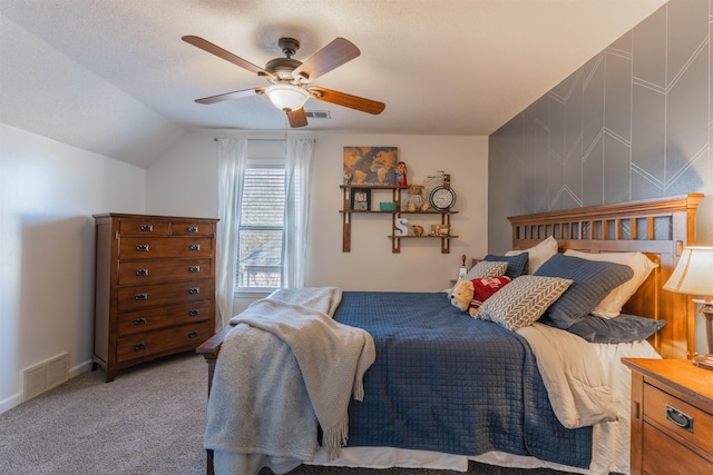 carpeted bedroom featuring lofted ceiling, a textured ceiling, and ceiling fan