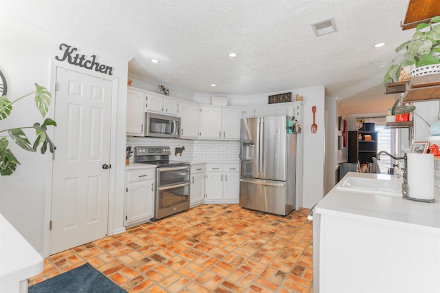 kitchen with sink, stainless steel appliances, white cabinets, and decorative backsplash