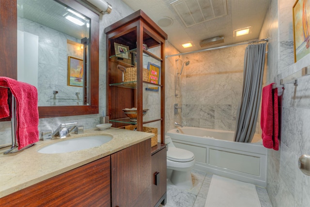 full bathroom with tile walls, toilet, vanity, and shower / bath combo