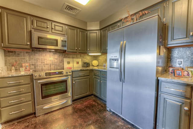 kitchen featuring stainless steel appliances, light stone countertops, and gray cabinets