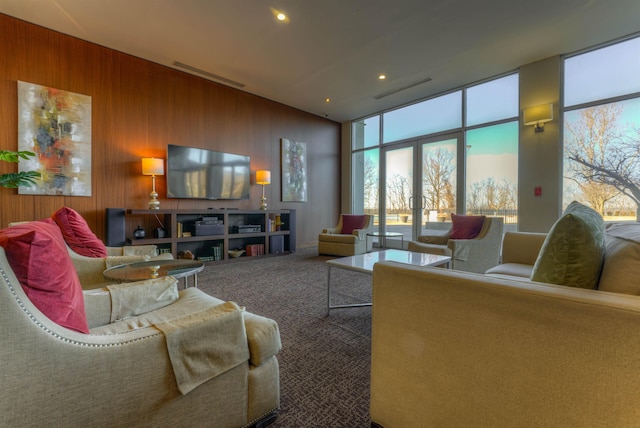 living room featuring wood walls, carpet, and french doors