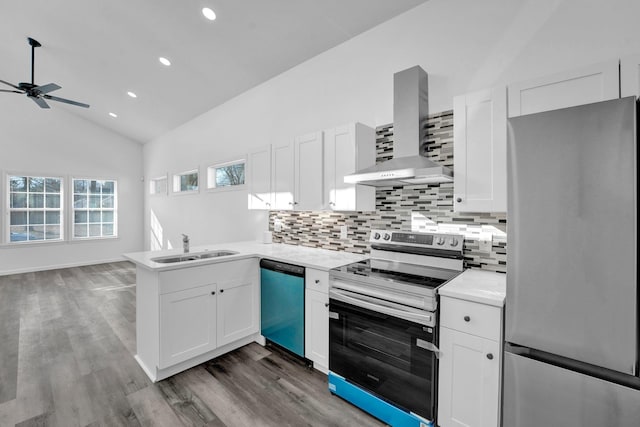 kitchen with high vaulted ceiling, wall chimney range hood, white cabinets, and stainless steel appliances