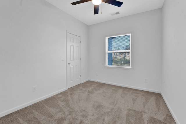 carpeted spare room featuring ceiling fan