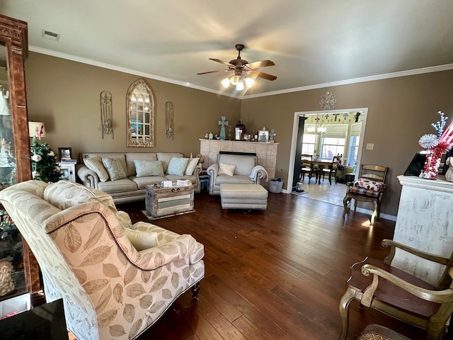 living room featuring ceiling fan, crown molding, dark hardwood / wood-style floors, and a fireplace