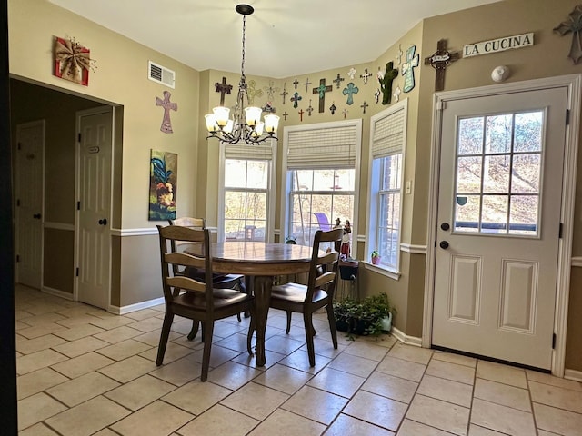 tiled dining room with plenty of natural light and a notable chandelier