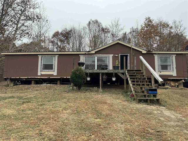 rear view of property featuring a lawn and a deck