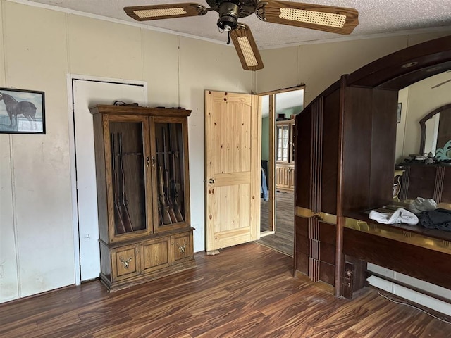 bedroom featuring ceiling fan, ornamental molding, dark hardwood / wood-style floors, and a textured ceiling