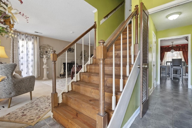 stairway with a textured ceiling and a healthy amount of sunlight