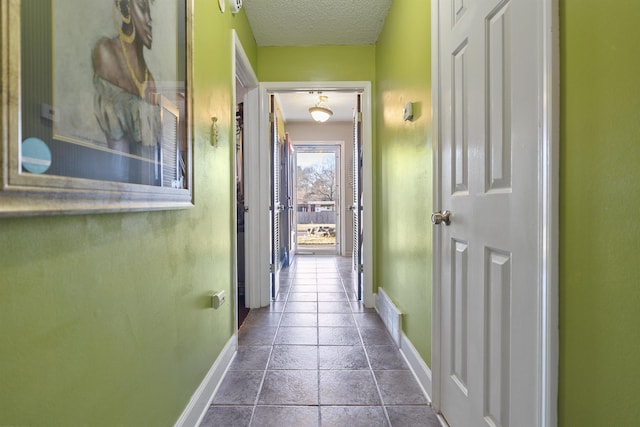 corridor featuring tile patterned floors and a textured ceiling