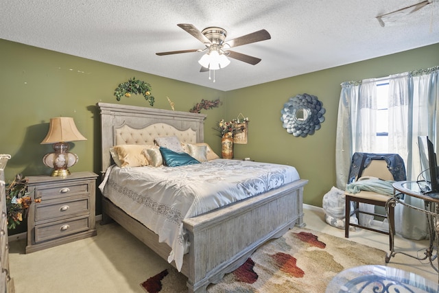 carpeted bedroom with ceiling fan and a textured ceiling