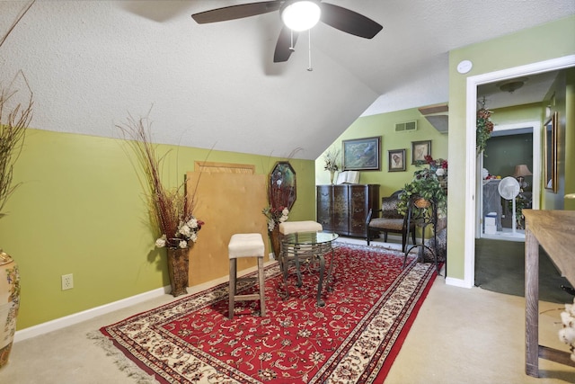 sitting room featuring a textured ceiling, carpet flooring, and lofted ceiling