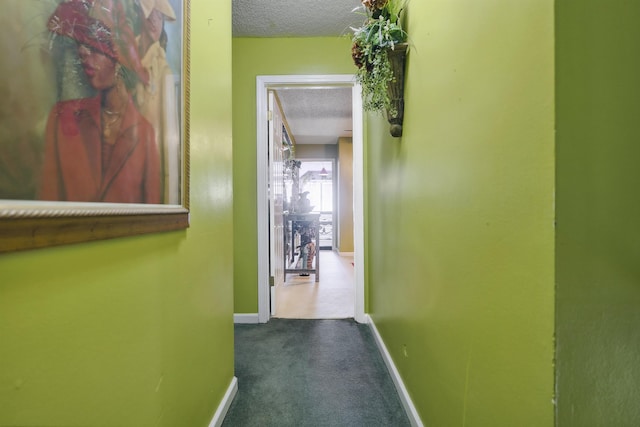 hallway with carpet floors and a textured ceiling