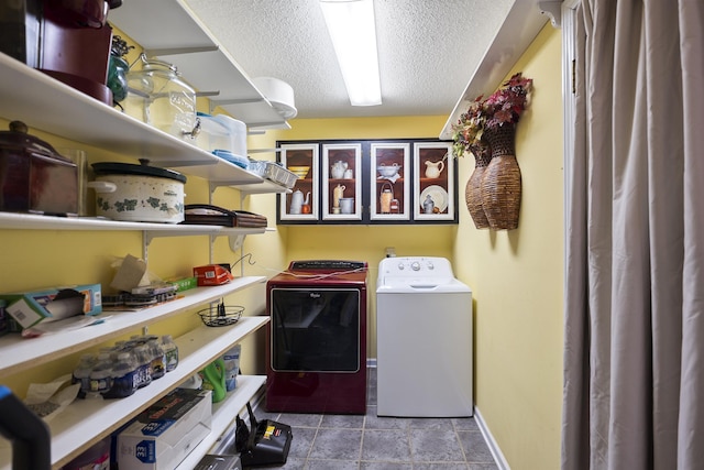 laundry area with a textured ceiling and washing machine and dryer