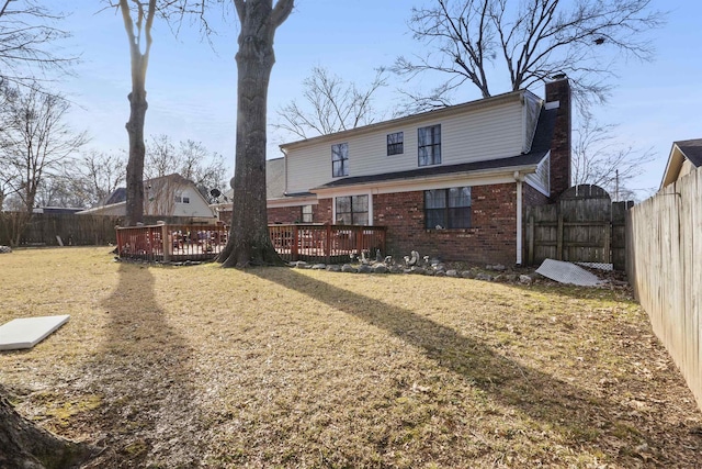 rear view of house with a deck and a lawn