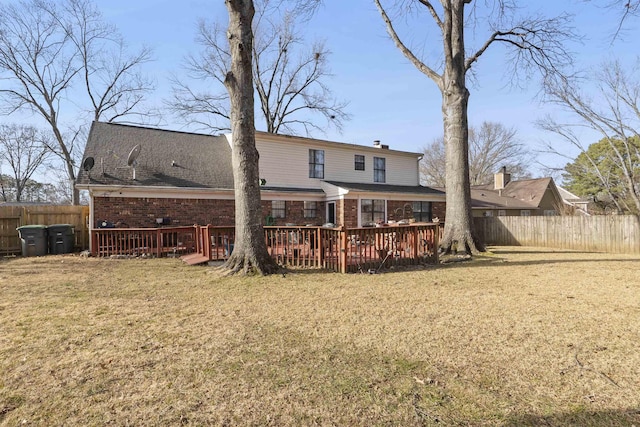 back of property featuring a lawn and a wooden deck