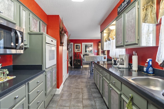 kitchen featuring sink, a textured ceiling, and green cabinets