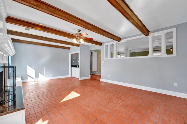 unfurnished living room with beamed ceiling, ceiling fan, and a premium fireplace