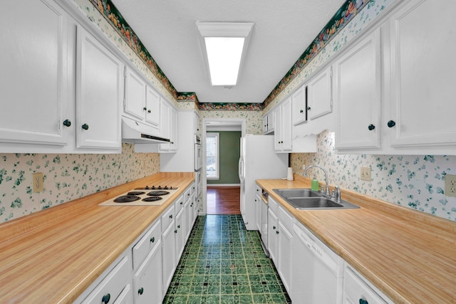 kitchen with sink, white appliances, and white cabinets