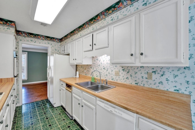 kitchen with sink, white appliances, and white cabinets