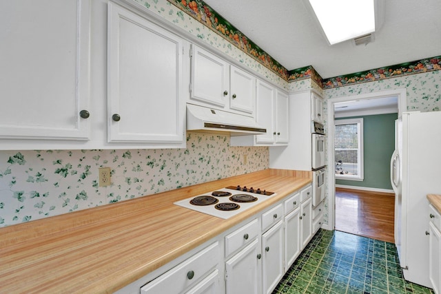 kitchen featuring white cabinets and white appliances