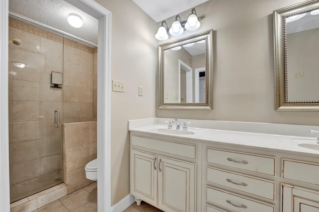 bathroom featuring a textured ceiling, tile patterned floors, vanity, toilet, and a shower with shower door