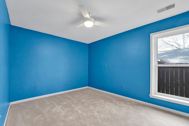 unfurnished room with ceiling fan and light carpet