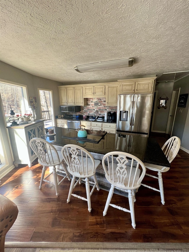 kitchen featuring cream cabinets, appliances with stainless steel finishes, a textured ceiling, sink, and dark hardwood / wood-style flooring