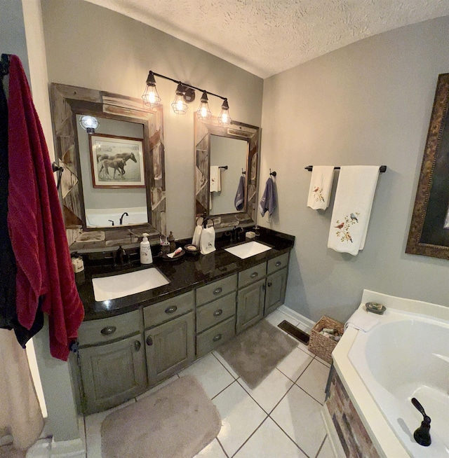 bathroom featuring vanity, tile patterned floors, a textured ceiling, and a bathing tub