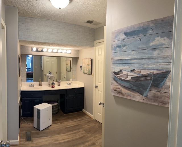 bathroom with wood-type flooring, a textured ceiling, and vanity