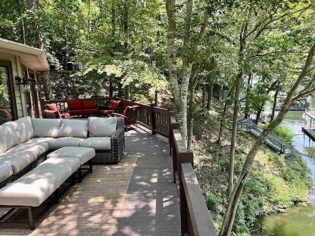 view of patio with outdoor lounge area and a deck with water view